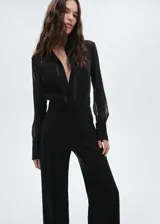 Mono largo negro de tejido fluido semitransparente, con cuello camisero, cierre frontal de botones ocultos, mangas largas con puños abotonados y diseño recto.