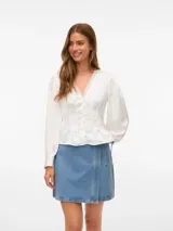 Blusa blanca de manga larga con cuello en V y cierre frontal de botones. Presenta mangas con volumen y puños abotonados, confeccionada en tejido plano.