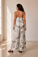 Mono largo bordó de satén con estampado sutil, escote en V con detalle en contraste y tirantes finos ajustables. Presenta pantalón de corte amplio y holgado.