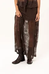 Pollera larga de encaje color chocolate, con diseño traslúcido y corte fluido.
