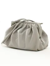 Cartera de mano de cuero color gris claro, con diseño fruncido y cierre metálico.