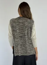 Chaleco de punto gris con diseño de trenzas.