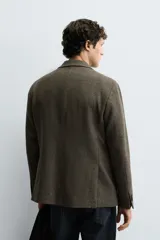 Blazer de corte regular confeccionada en tejido de lana. Presenta cuello con solapas de muesca, cierre frontal de un botón, bolsillos de solapa en la cadera y bolsillo de vivo en el pecho.