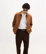 Pantalón de corte recto para hombre, color marrón, confeccionado en sarga. Cuenta con cintura con trabillas, cierre frontal tradicional y bolsillos laterales y traseros.