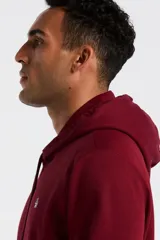 Hoodie de color bordó con capucha ajustable mediante cordones, bolsillo frontal tipo canguro y logo de la marca bordado en el pecho.