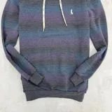 Canguro rústico con capucha, de mangas largas y estampado a rayas horizontales en tonos gris, azul y violeta.