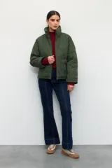 Campera corta color marrón con diseño capitoneado de rombos, cuello alto y bolsillos frontales grandes.