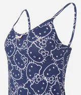 Pijama short doll de dos piezas en color azul marino con estampa integral de Hello Kitty en tono claro. Consta de una musculosa de tirantes finos con escote en V decorado con un pequeño lazo y un short con cintura elástica.