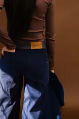 Pantalón de paño combinado con tira de cuero color marrón.