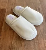 Pantuflas de dama color blanco, con diseño de punta cerrada y plataforma. Presentan una etiqueta con la marca Zephia en la plantilla.