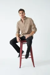 Camisa manga larga verde oliva con fit regular, mangas con botones y logo bordado.