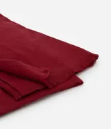 Pañuelo de poliéster color azul, con diseño liso y terminaciones de mini flecos en los extremos.