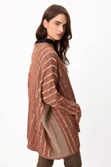 Sweater de tejido artesanal con diseño de rayas verticales en tonos camel y beige, corte holgado, cuello redondo y puños altos ajustados.