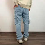 Pantalón tipo jean cargo de corte recto y tiro medio, en color azul claro lavado. Presenta bolsillos laterales con solapa y cierre de botón y cremallera.