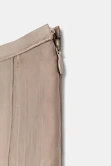 Falda midi de tiro medio de la colección ZARA Woman, confeccionada en mezcla de lyocell con acabado fluido y bajo en línea evasé. Cuenta con forro interior a tono y cierre lateral con cremallera oculta.