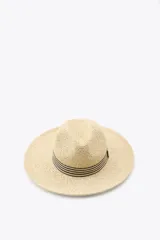 Sombrero trenzado de ala ancha en color beige natural, con detalle de cinta decorativa a rayas horizontales en contraste alrededor de la copa.