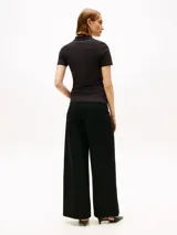 Chomba Tommy Hilfiger de piqué de algodón orgánico elástico, color negro, corte slim, cuello clásico y cartera de cuatro botones.