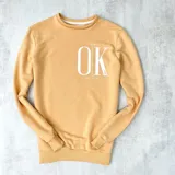 Buzo color naranja con estampa frontal de la frase "It's OK, don't worry" en color blanco.