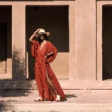 Sandalias de cuero color marrón con textura efecto cocodrilo, diseño de tira ancha en el empeine, tira trasera ajustable y suela plana con plataforma baja.
