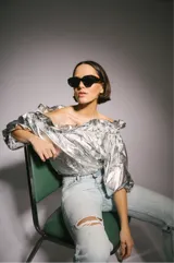 Blusa plateada con escote off-shoulder y mangas 3/4 abullonadas con elástico en los puños.