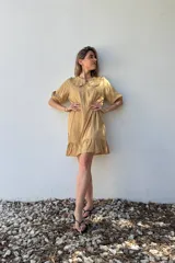 Vestido corto color beige de voile de rayon, con cuello bebé con volados y mangas cortas abullonadas.