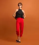 Pantalón zanahoria de tiro alto color rojo, con cierre tradicional, pliegues y botón en el bajo.