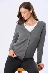 Saco tejido fino de hilo de algodón color beige, con cuello en V, cierre frontal con botones y puños acanalados.