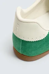 Zapatilla de cordones de estilo retro, con parte superior de serraje color bordó y detalles en piel lisa color rojo. Suela ultrafina de goma en tono marrón oscuro.