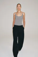 Pantalón de lana negro de tiro medio con trabillas en la cintura, bolsillos laterales ocultos y pierna ancha.