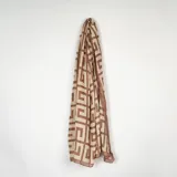 Pashmina rectangular con estampado geométrico en tonos marrón y beige.