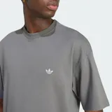 Remera Adidas de manga corta, color gris, de corte holgado, con cuello redondo y el logo de la marca bordado en el pecho.