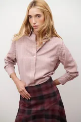 Camisa de mujer a rayas verticales blancas y rosadas, con cuello clásico, cierre de botones frontal y mangas largas con puños abotonados.