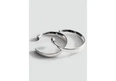 Pendientes de tipo argolla grande, de diseño clásico y acabado metálico plateado.