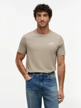 Remera de manga corta y cuello redondo en color caqui, confeccionada en puro algodón, con sutil logo bordado en el pecho y etiqueta distintiva en la manga.