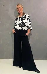 Pantalón de vestir negro, estilo oxford, confeccionado en viscosa y lycra, con pretina frontal, elástico en la parte trasera y bolsillos laterales.