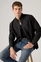 Camisa de manga larga color negro lavado, con cuello camisero con botones y cierre frontal abotonado.