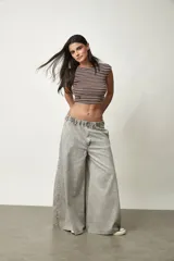 Jean de corte wide leg y tiro bajo, en color gris claro con efecto acid wash, cintura elastizada y bolsillos.