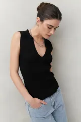 Top negro tejido sin mangas con escote en V y cuello tipo solapa.