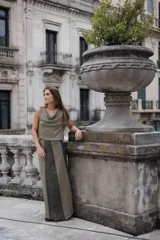 Pollera larga de corte recto con diseño bicolor, combinando paneles de tejido texturizado en tono oliva claro y paneles centrales de cuero en tono verde oscuro. Presenta un estilo minimalista y sofisticado.