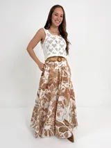 Falda larga de algodón con estampado floral en tonos azul y blanco. Tiene elástico en la cintura y viene con un cinto de rafia elastizado, desmontable.