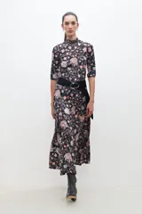 Polera negra con estampado floral estilo búlgaro, cuello alto y mangas 3/4.