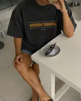 Remera marrón oversize de manga corta con estampado gráfico en la espalda de dos gatos de estilo retro con cuchillos y texto "Kahoa Industries".