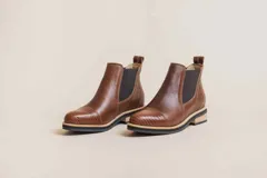 Botas Chelsea de cuero color marrón, con elástico lateral y detalle de textura en la puntera.