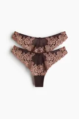 Pack de dos bombachas estilo Brazilian de tiro bajo, confeccionadas en malla marrón con apliques de encaje floral en tono rosado y detalle de pequeño lazo en la cintura.