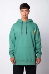 Buzo canguro gris claro de corte oversize, con capucha y cordones negros con letras blancas. Presenta un bolsillo tipo canguro y un estampado pequeño en el pecho y otro en la manga.