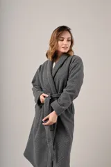 Bata de polar gris con textura labrada, diseño cruzado con lazo ajustable en la cintura, bolsillos laterales y mangas largas.