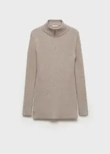 Jersey de punto acanalado color beige, con cuello alto y cierre frontal parcial. Presenta un diseño entallado de largo medio y mangas largas con terminación acampanada.