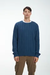 Sweater azul de punto trenzado con cuello redondo y mangas largas.