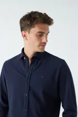 Camisa manga larga verde oliva con fit regular, mangas con botones y logo bordado.