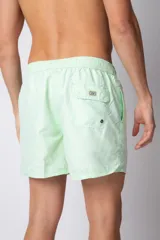 Short de baño color verde menta con efecto desgastado, cintura elástica con cordón ajustable y bolsillos laterales.